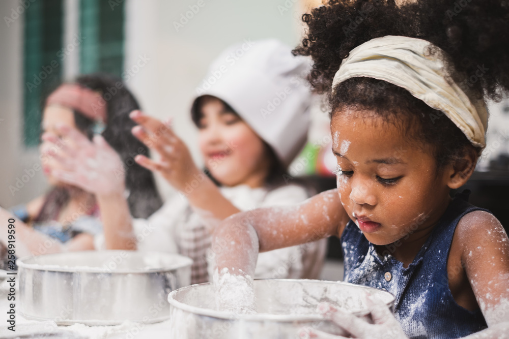 团体多样性儿童女孩在厨房做蛋糕面包店