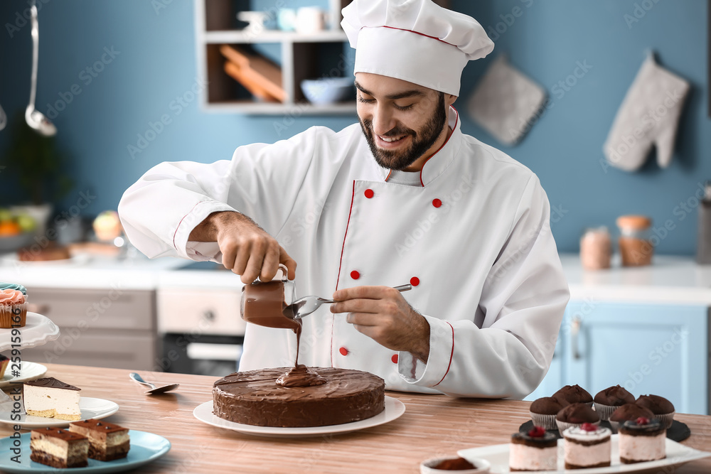 男糖果师在厨房装饰美味的巧克力蛋糕