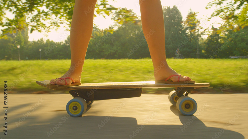 特写：一个不知名的女人在公园里骑着她的电动滑板滑冰。
