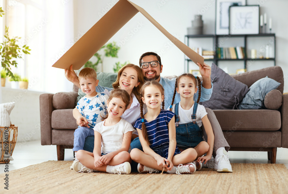 住房和搬迁的概念。幸福的大家庭父母和家里有屋顶的孩子。