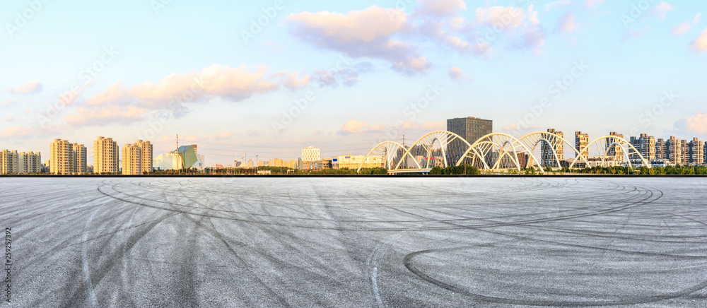 日落时上海的沥青赛道地面和城市天际线全景，桥梁施工