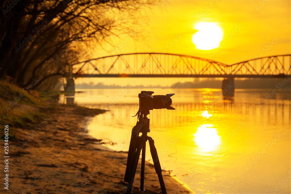 三脚架相机的剪影，背景是令人惊叹的日落
