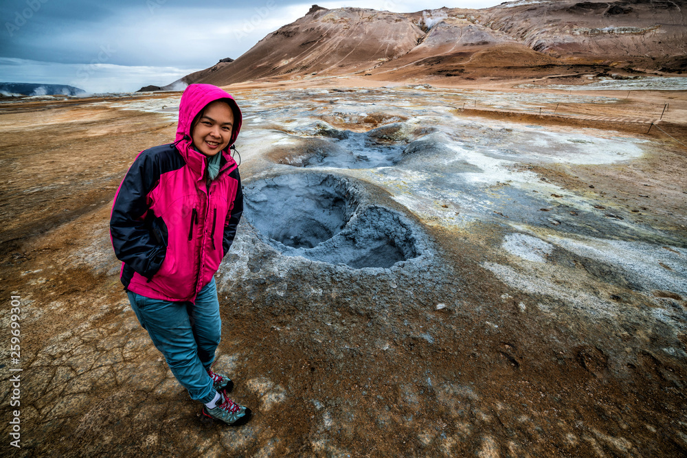 Woman traveler travels to Hverir in Iceland. Hverir (Icelandic: Hverarond) is geothermal area in Myv