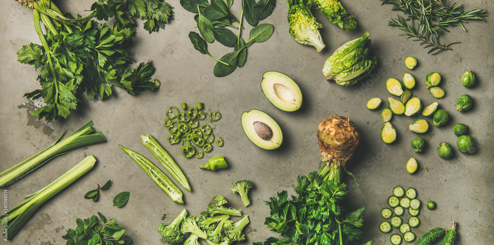 健康的纯素食食材布局。将整份和切好的绿色蔬菜和可食用的香草平铺在c上