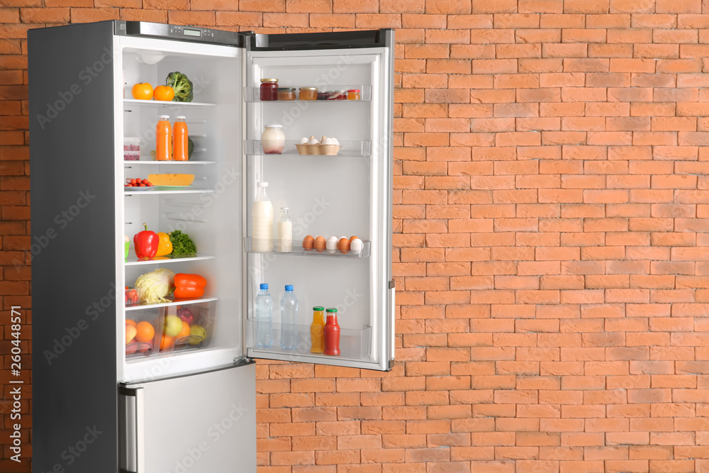 打开砖墙附近装满食物的冰箱