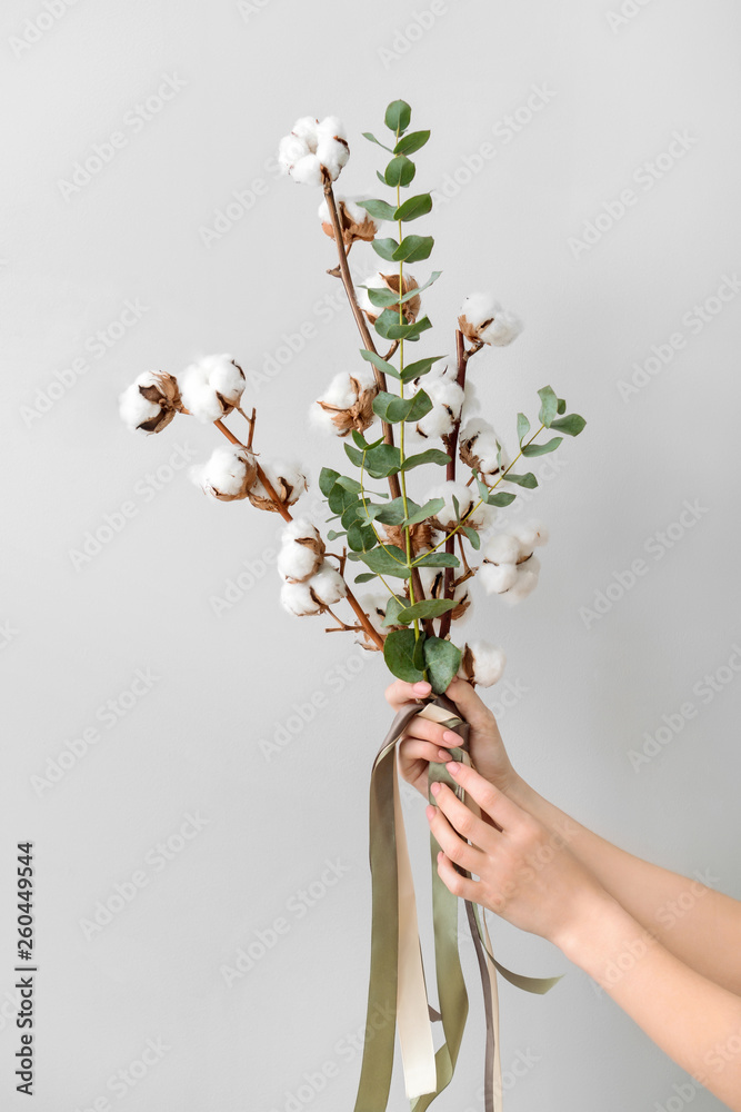 女性手拿花卉作品，浅色背景为棉花花