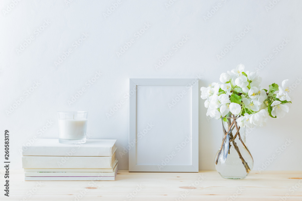 室内装饰元素。白色框架，花瓶里的白色春花，室内装饰