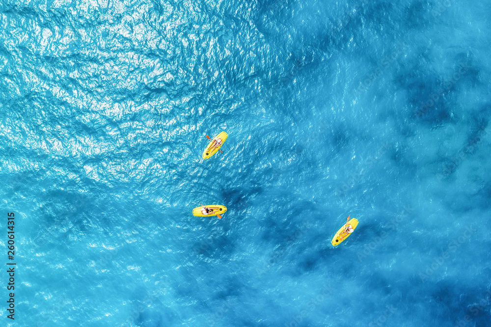 夏日阳光明媚的日子里，人们在蓝色大海中乘坐皮划艇的鸟瞰图。非洲桑给巴尔。