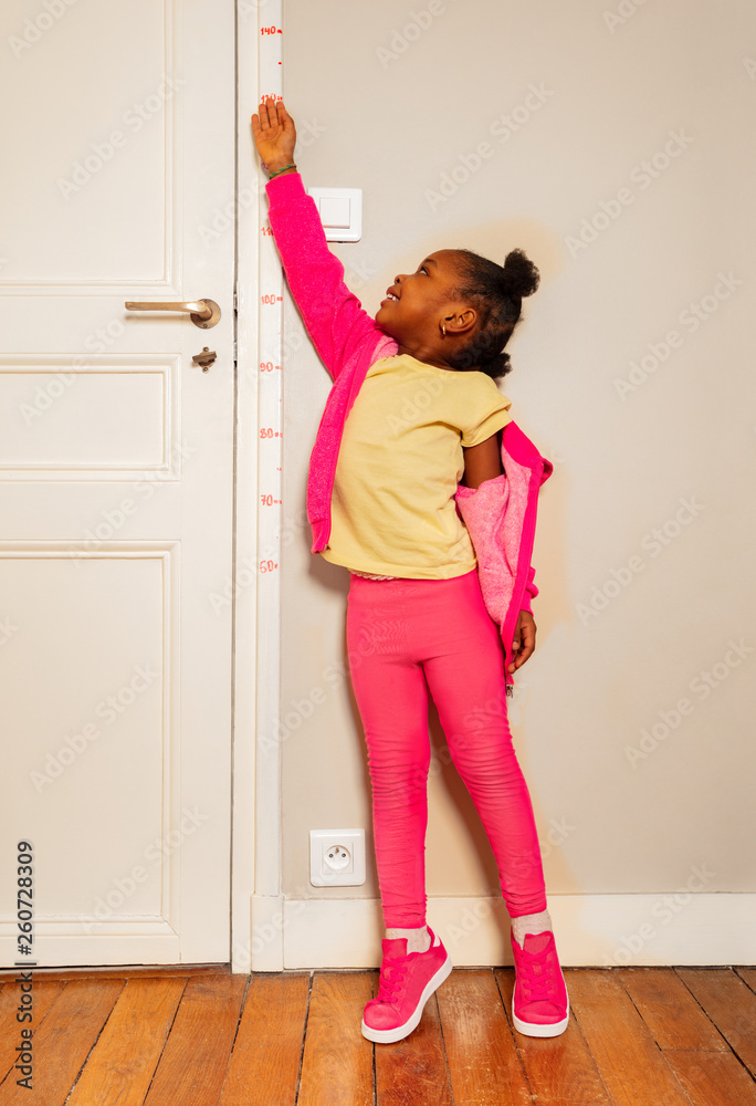 Small black girl cheat to look high on door scale