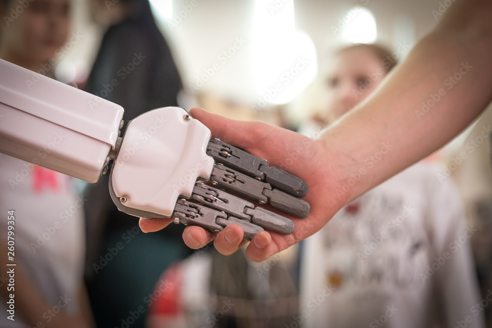 人类和机器人握手。人类与人工智能互动的概念