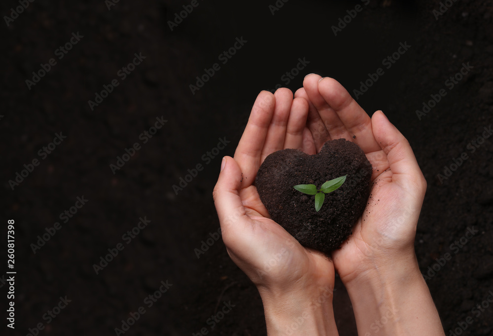 Hands holding soil in the shape of a heart.Earth day concept.