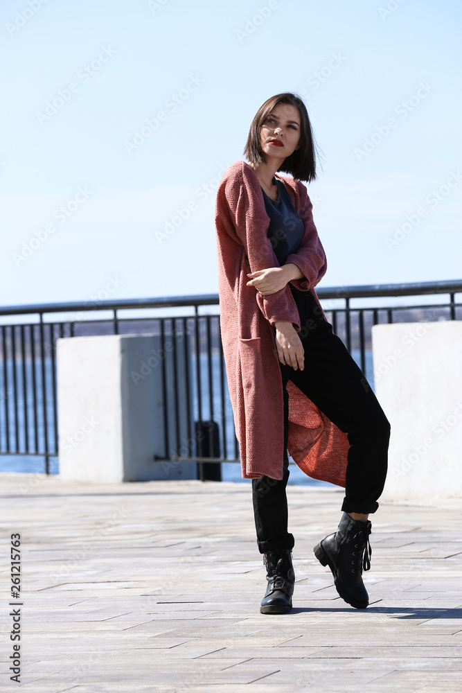 Fashionable young woman on embankment