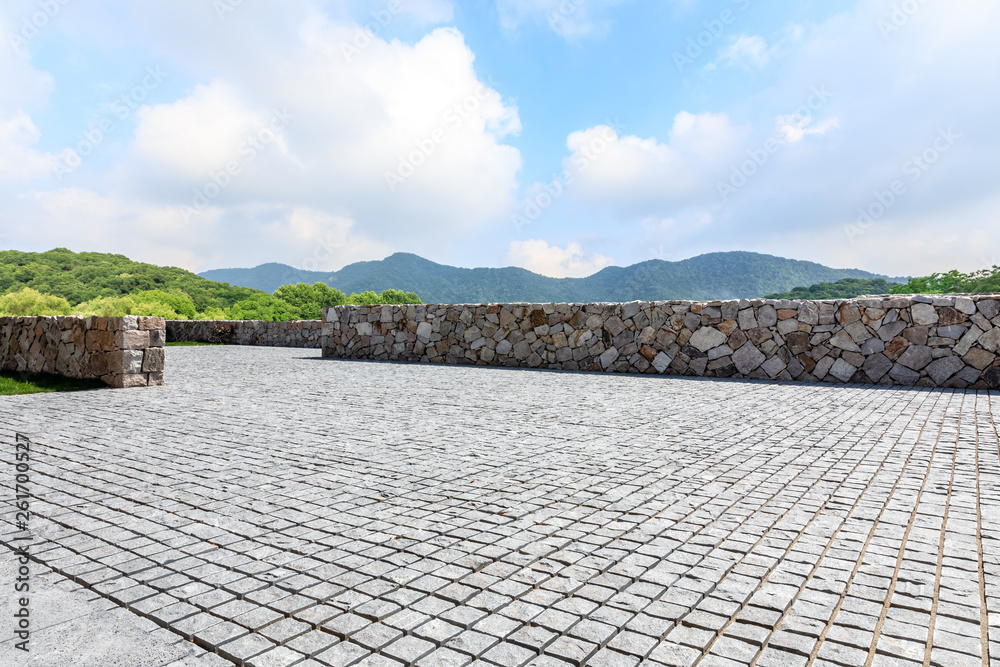 Rough square stone floor and green mountain with sky landscape