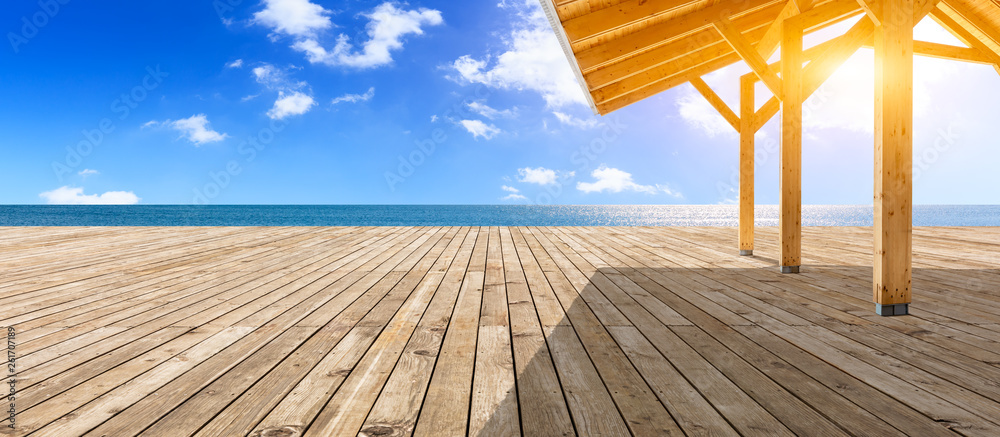 Wooden floor platform and blue sea with sky background