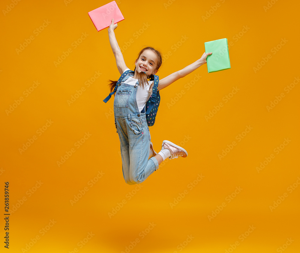 funny child school girl girl jumping yellow background    .