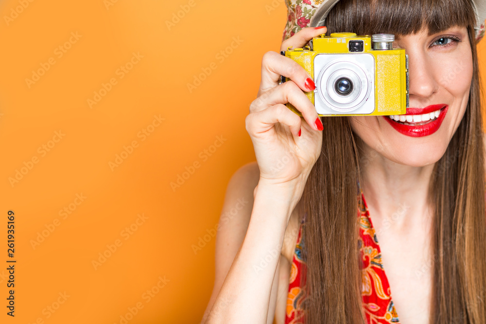 Beautiful travel woman with old camera concept over colorful background