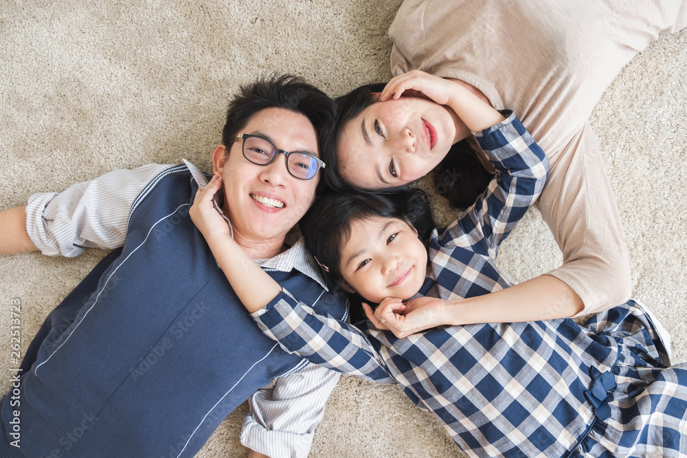 幸福的亚洲家庭幸福地躺着，微笑着，俯视图