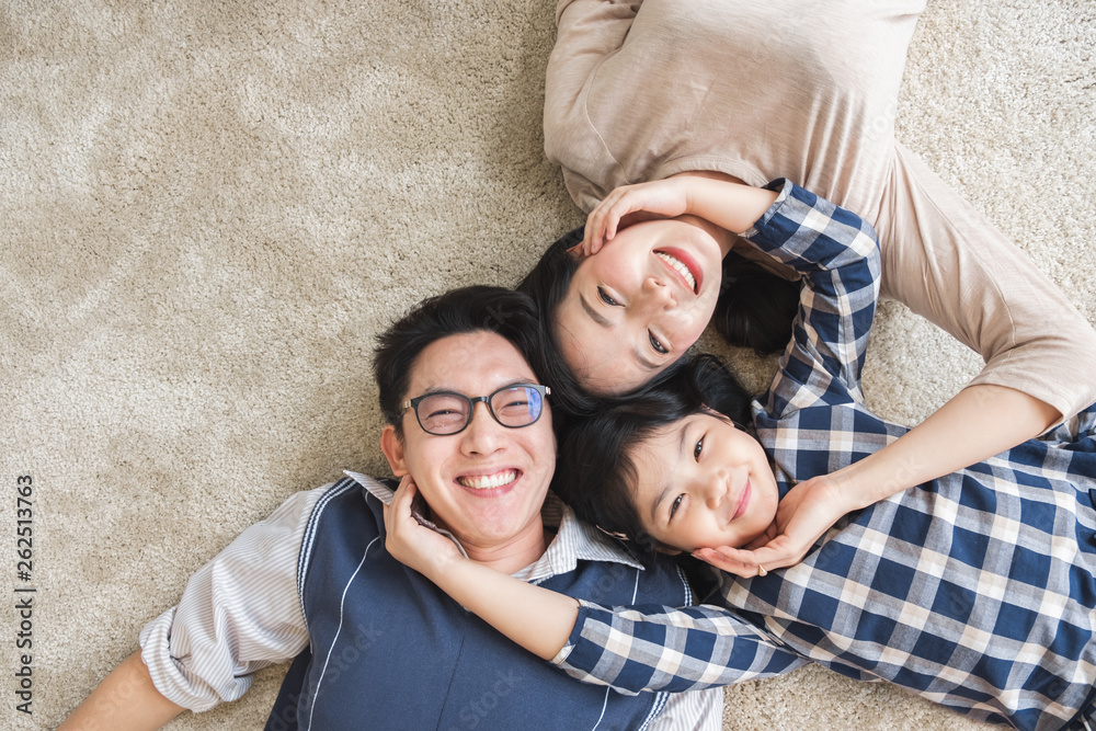幸福的亚洲家庭幸福地躺着，微笑着，俯视图