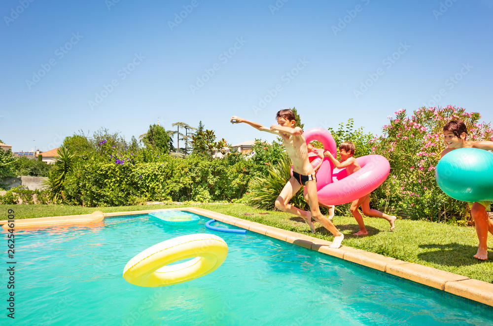 有趣的孩子拿着游泳池玩具跳进水里