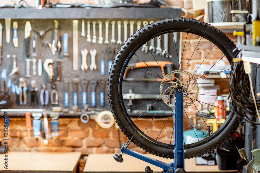 调校过程中带轮子的自行车车间和背景上的工作工具