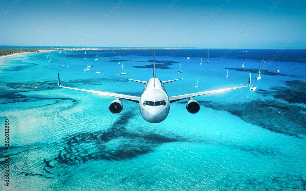 夏天日出时，飞机在岛屿和海上飞行。白色客机的景观