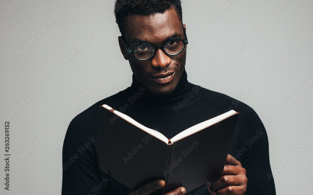 拿着一本书的非洲男人