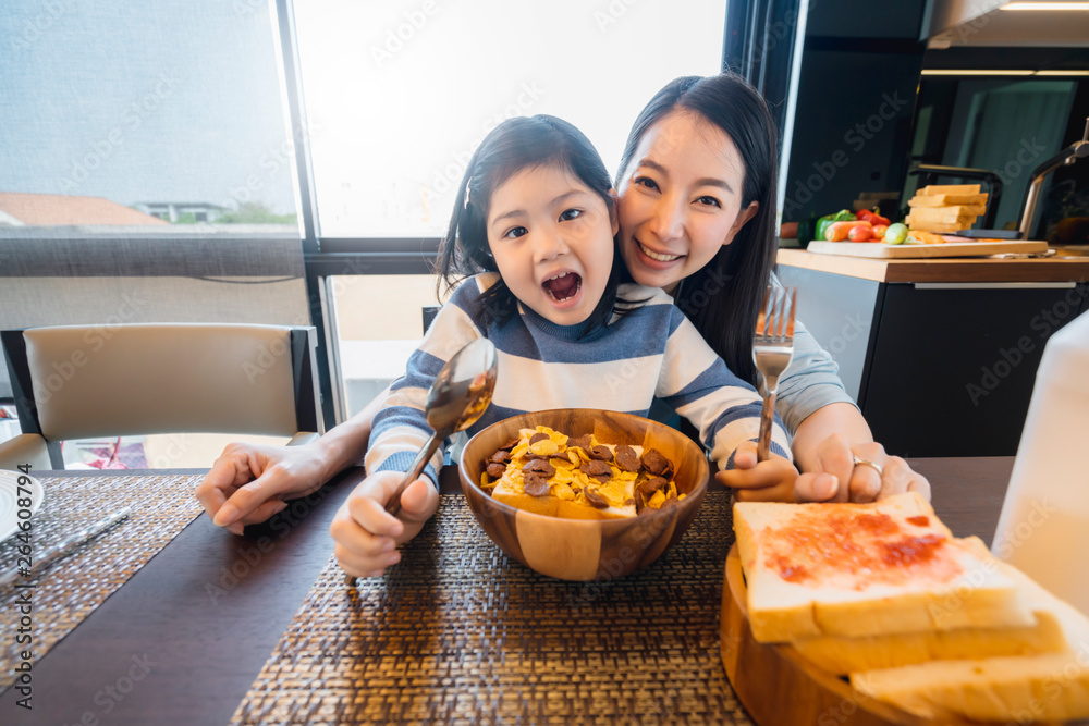happiness asian mom and daughter enjoy cereal breakfast time healthy food concept dinning room backg