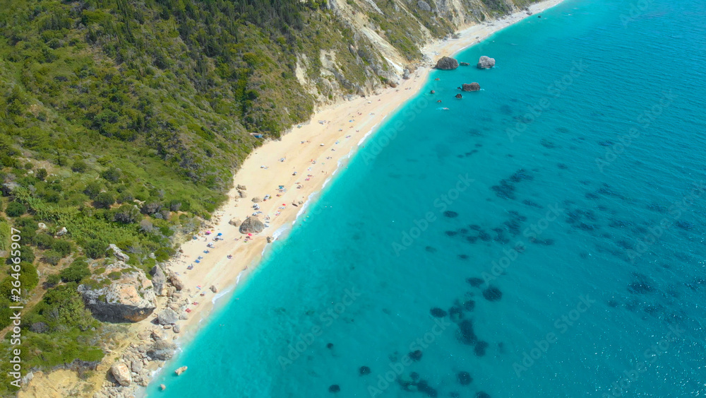 无人机：无忧无虑的游客在偏远的海滩上享受暑假。