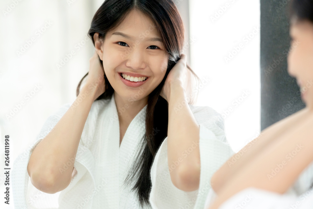 beautiful asian woman bathing dress hair brush and dress up with reflecting mirror bathroom backgrou