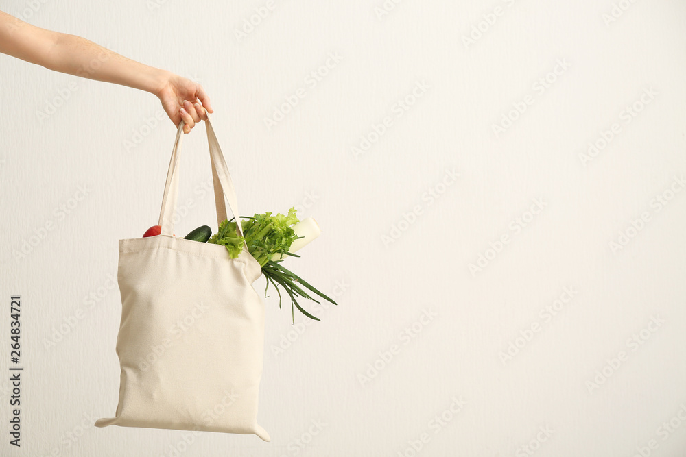 女性手，白色背景环保袋。零浪费概念