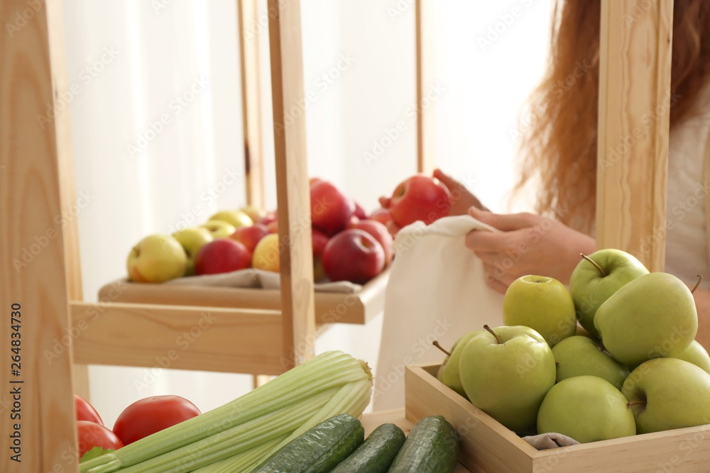 妇女带着环保袋在商店里买水果。零浪费概念