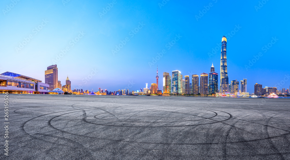 上海夜晚的沥青赛道场地和现代天际线和建筑，全景