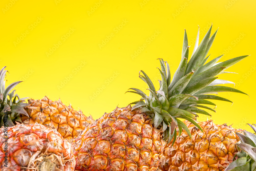 美丽的新鲜菠萝被隔离在明亮的黄色背景上，夏季时令水果设计理念pa
