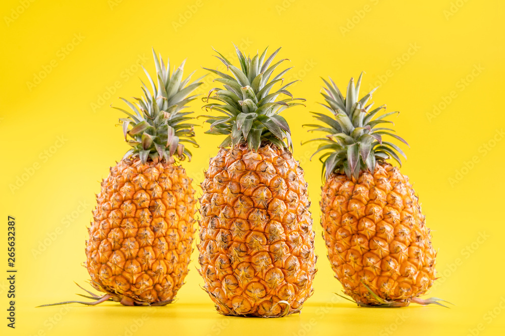 Beautiful fresh pineapple isolated on bright yellow background, summer seasonal fruit design idea pa