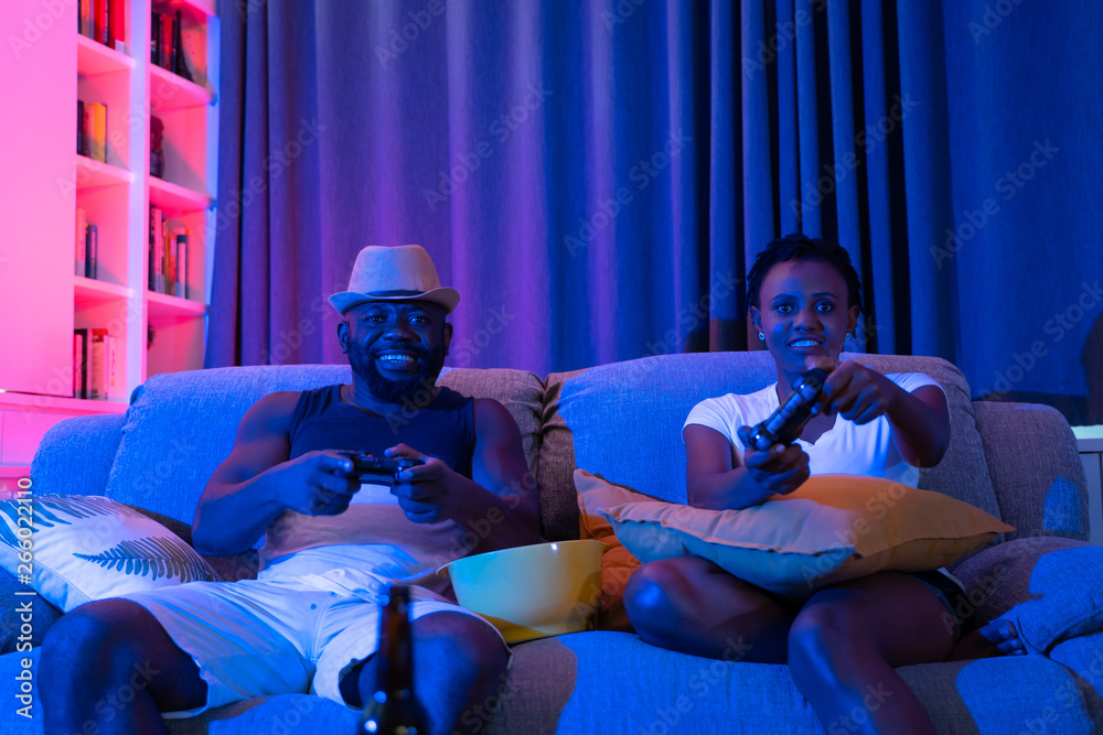 快乐的非洲夫妇在游戏机上玩电子游戏