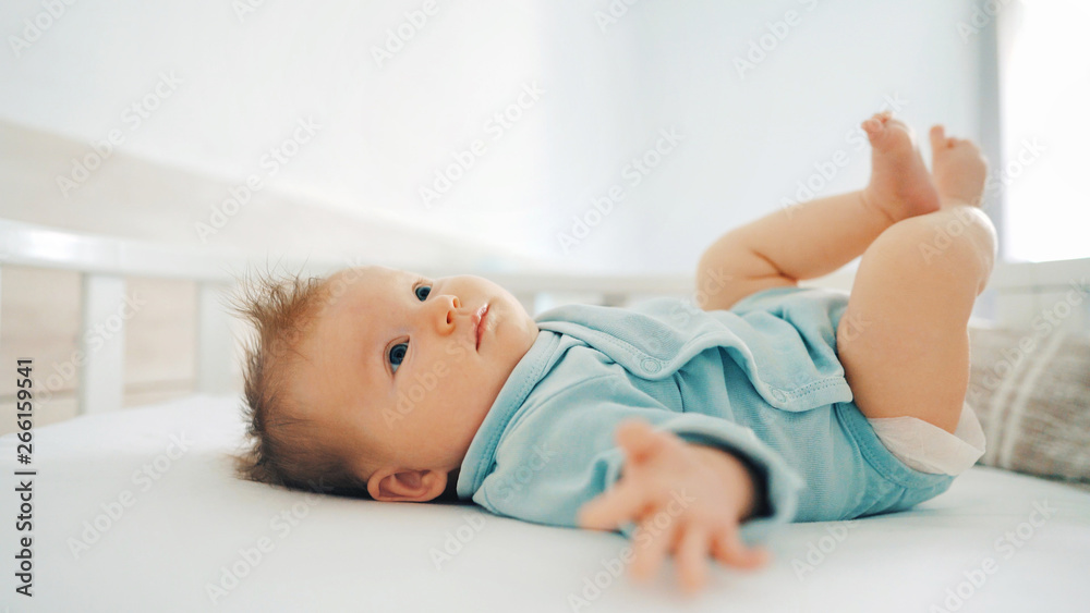 Infant girl lying on bed at home adorable 2 month old baby kid