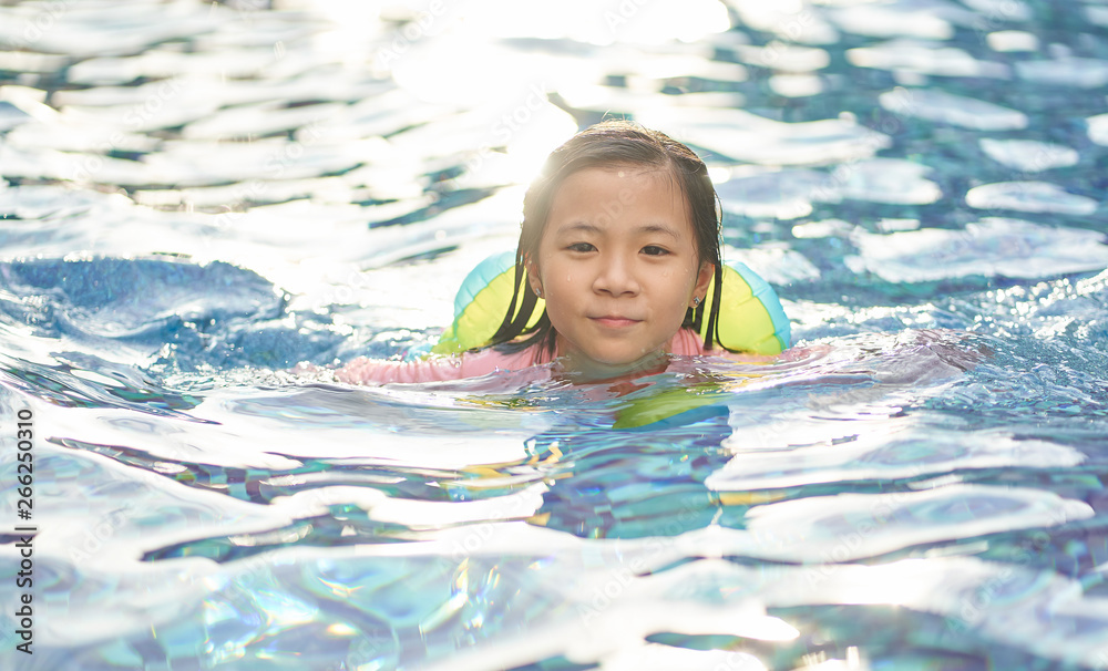 亚洲小女孩在游泳池玩得很开心