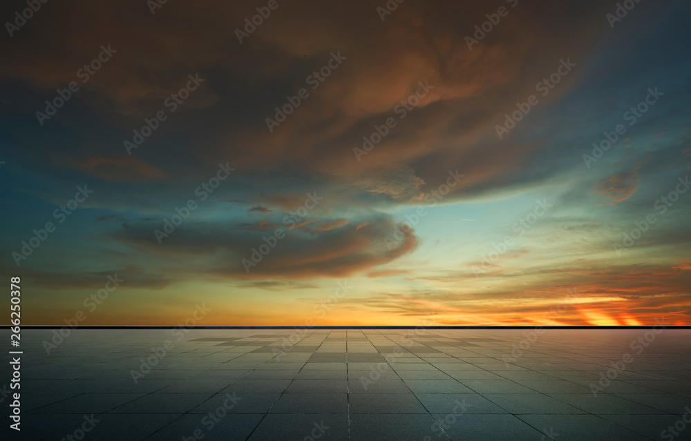 美丽的充满活力的橙色云层和蓝色的日落天空，空荡荡的沥青地板。
