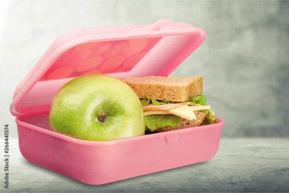 桌上有一个苹果和三明治的午餐盒