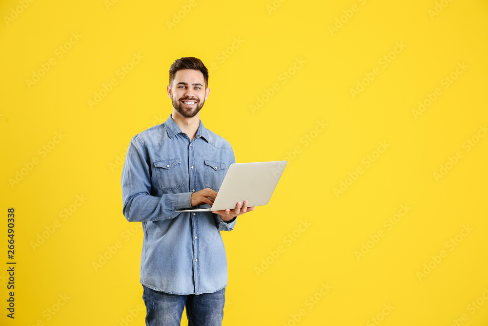 彩色背景带笔记本电脑的男程序员