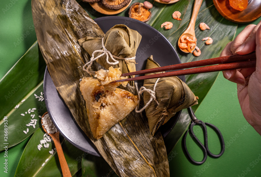 粽子，绿色餐桌背景下吃蒸饺的女人，端午节的食物