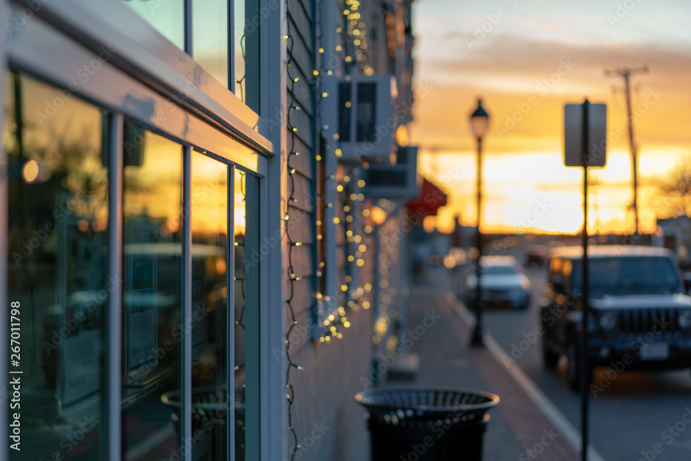 反映日落的店面窗户，小镇街道，靠近海港的海洋