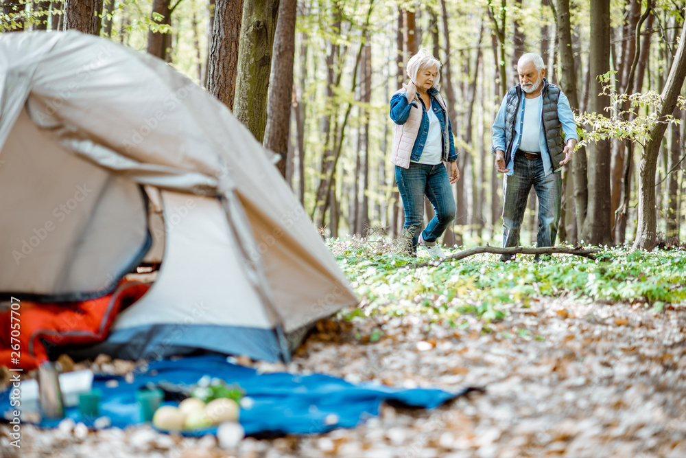 森林中的露营地，背景是一对老年夫妇