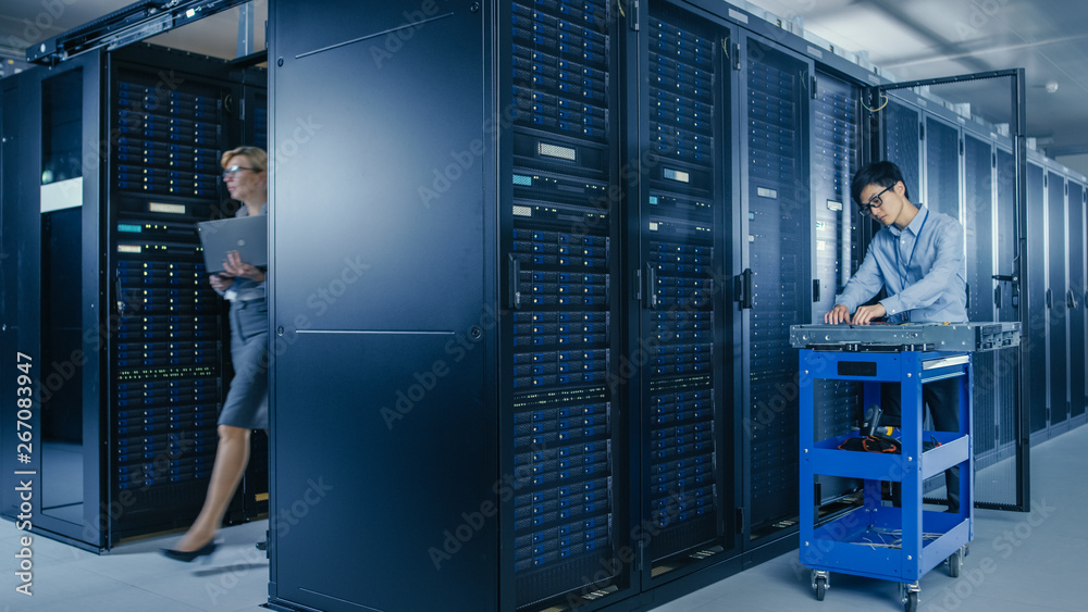 In the Modern Data Center: Team of IT Technicians Working with Server Racks, Man with Pushcart Chang