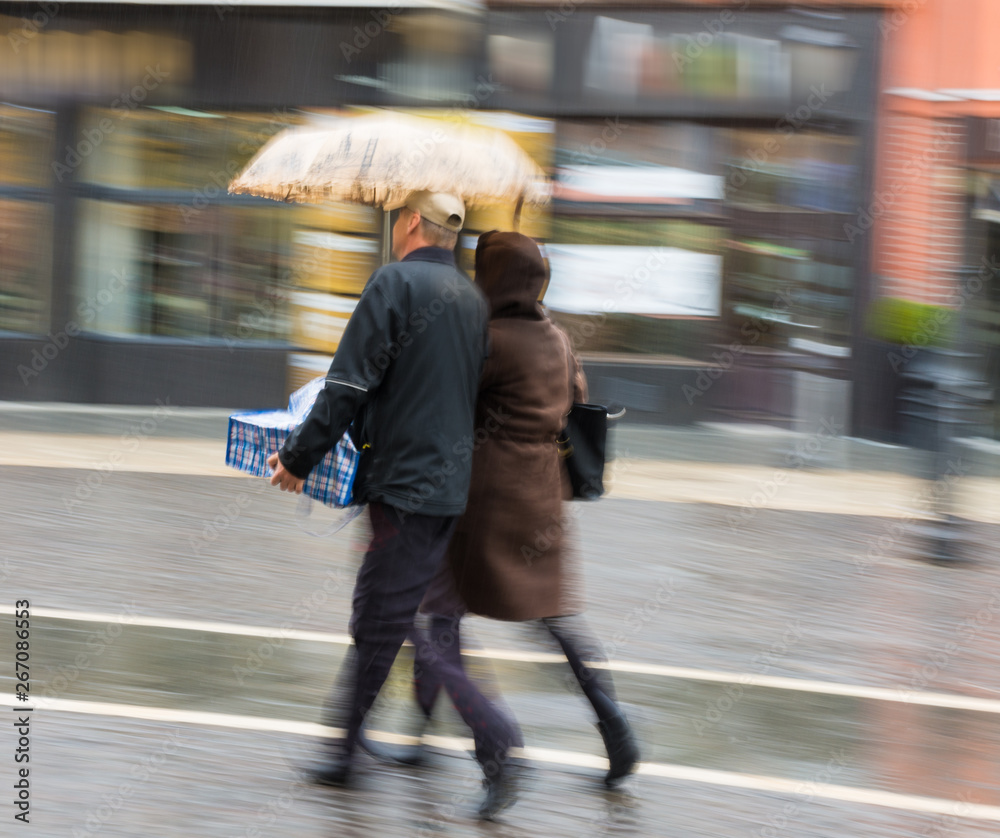 雨天人们带着雨伞走在街上