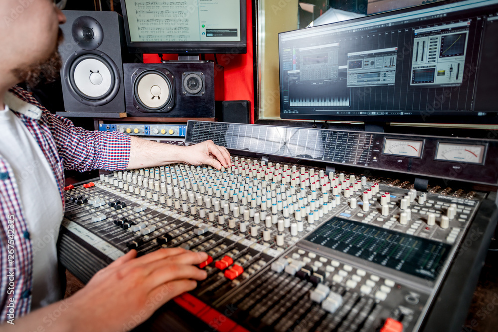 Sound producer working at recording studio using soundboard and monitors