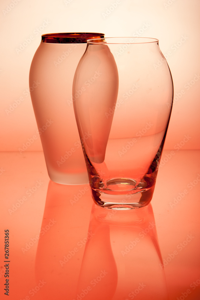 玻璃桌上红色背景的玻璃花瓶。