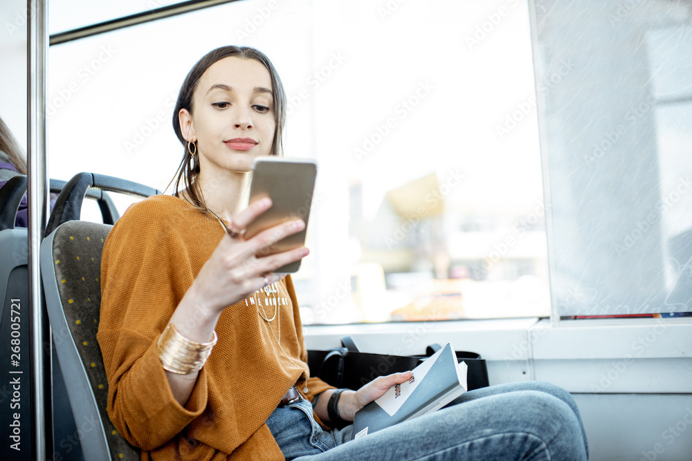 年轻快乐的女人坐在公共交通工具的窗户附近使用智能手机
1677016910,绿野落日