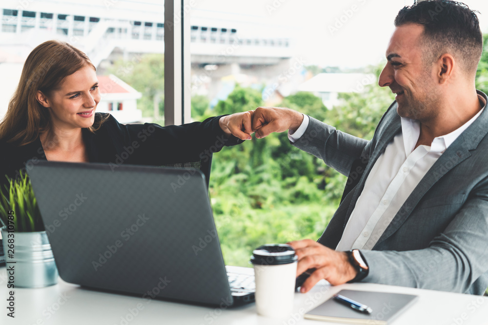 Success business partner - Businesswoman and businessman celebrating together in modern workplace of