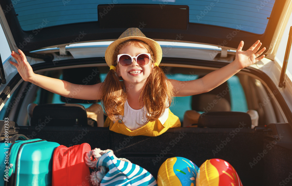 快乐的小女孩坐在车里去暑假旅行。